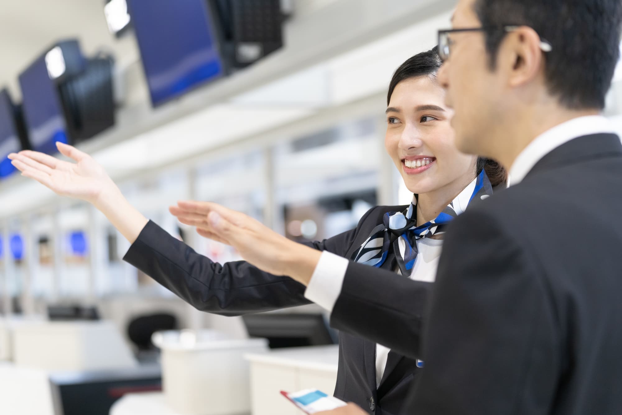 熊本空港航空会社グランんどスタッフ女性とお客様男性の案内風景